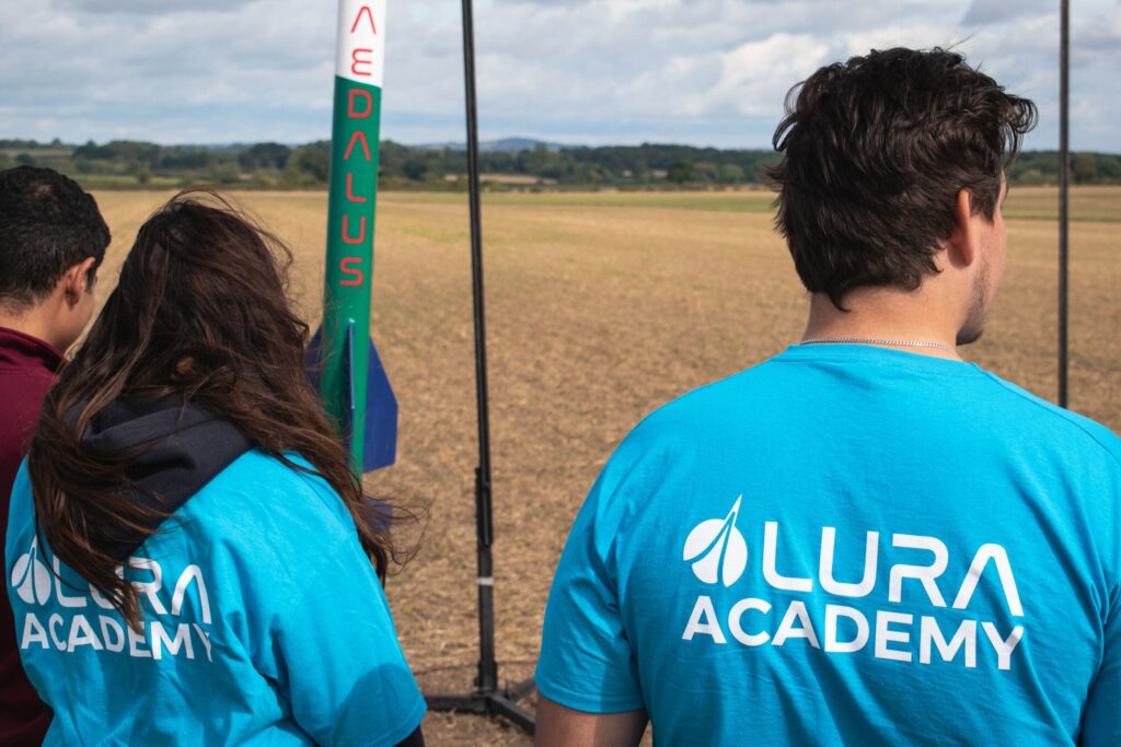 Image of the back of LURA Academy members showing off their Academy t-shirts