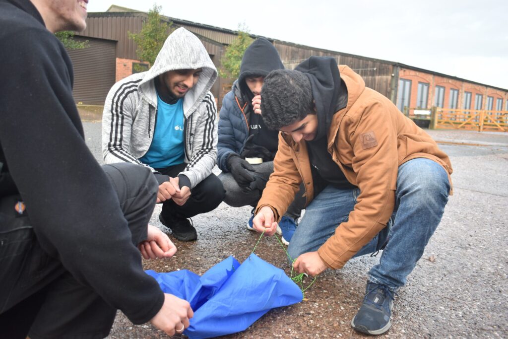 Image of LURA Academy members putting together their parachute for their rocket